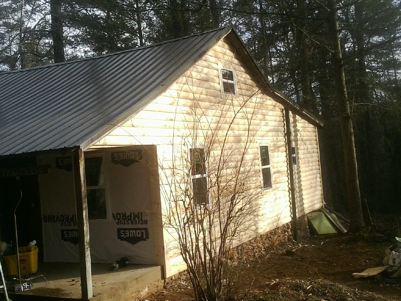 Log siding gable end under a dark metal roof edge in Florence